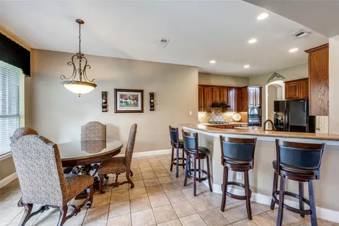 a dining room filled chandelier and wooden floor