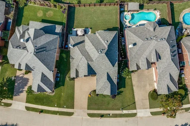 an aerial view of a house with a yard and pool