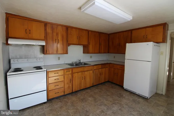 a kitchen with sink a refrigerator and cabinets