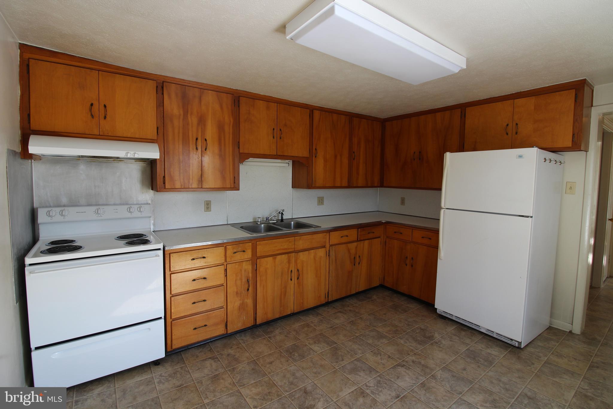 18947 Senedo Road, Unit 4 Edinburg, VA 22824 - Photo 4 of 15 a kitchen with sink a refrigerator and cabinets
