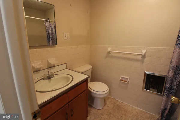 a bathroom with a granite countertop toilet sink and mirror