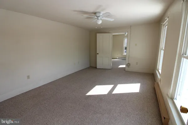 an empty room with a window and a ceiling fan