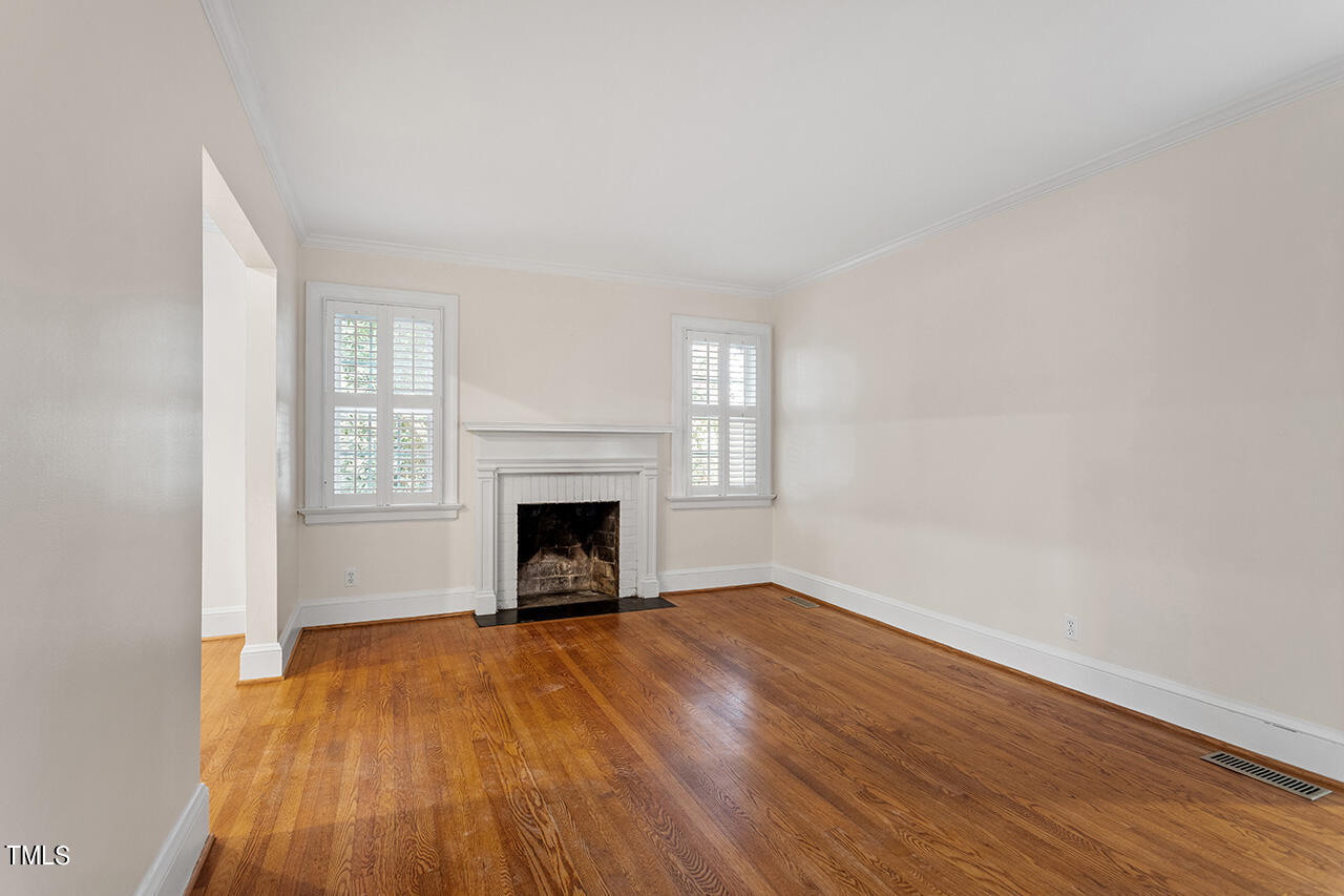 313 Furches Street Raleigh, NC 27607 - Photo 8 of 28 a view of empty room with wooden floor and fireplace