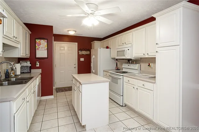 a kitchen with stainless steel appliances granite countertop a sink a stove a refrigerator cabinets and chairs