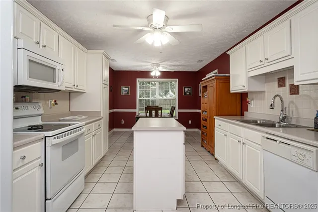 a kitchen with white cabinets and a sink
