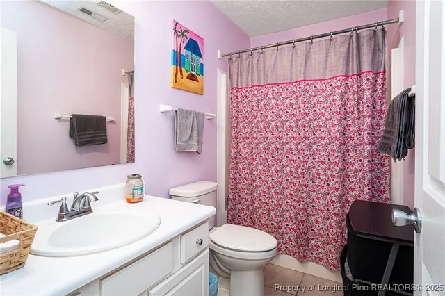 a bedroom with a bed a couch and a flat screen tv