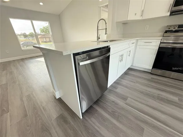 a kitchen with stainless steel appliances a refrigerator and a window