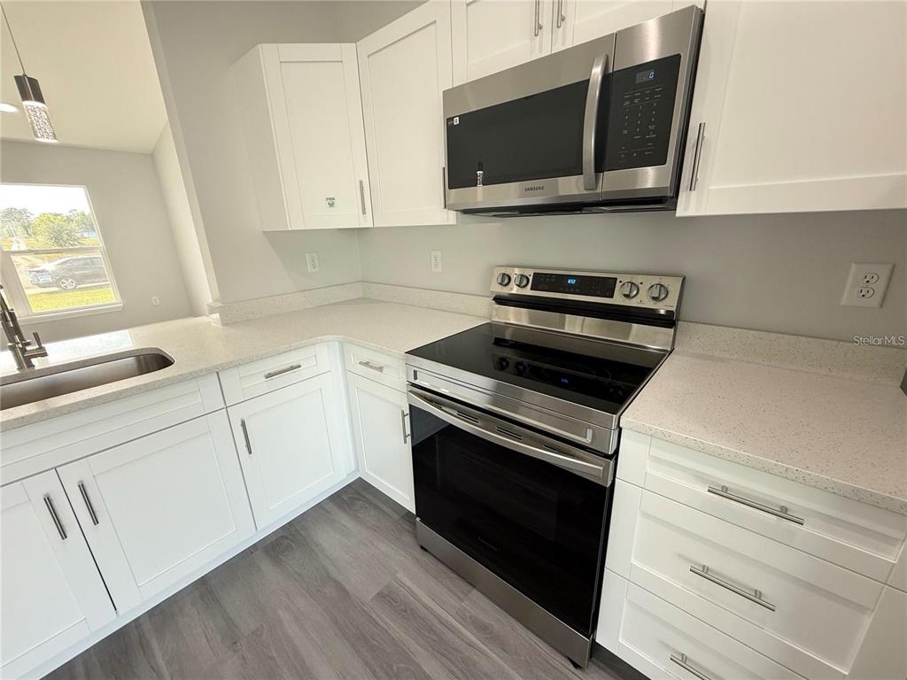3577 Southwest 149th Terrace Ocala, FL 34481 - Photo 14 of 31 a kitchen with white cabinets stainless steel appliances and sink