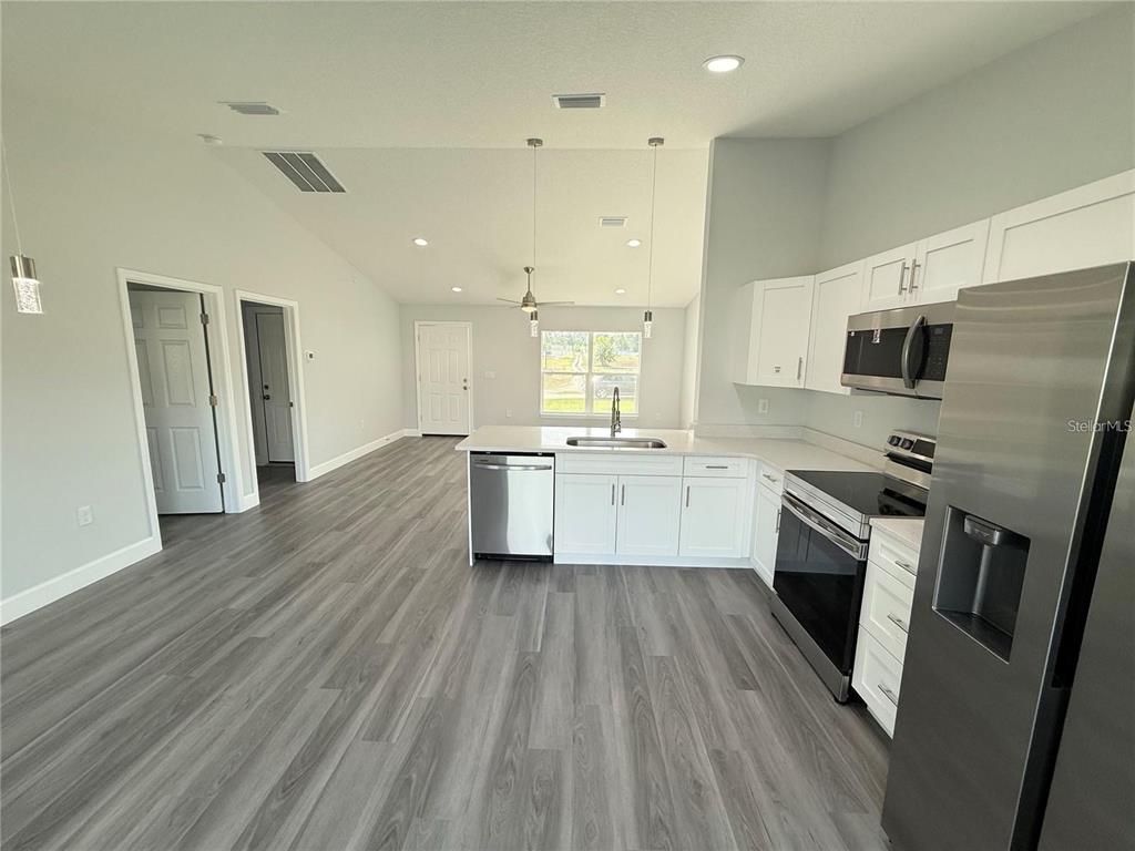 3577 Southwest 149th Terrace Ocala, FL 34481 - Photo 26 of 31 a large kitchen with a center island wooden floor stainless steel appliances and cabinets