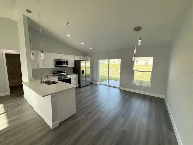 a kitchen with granite countertop a stove and a refrigerator
