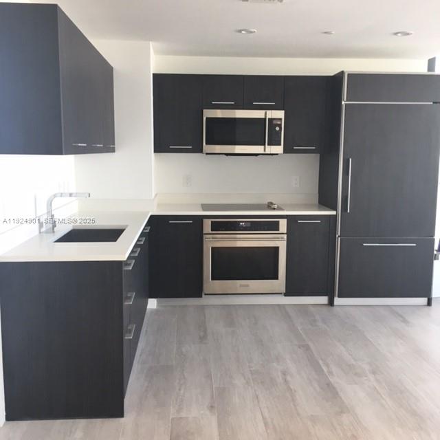 45 Southwest 9th Street, Unit 3201 Miami, FL 33130 - Photo 12 of 19 a kitchen with a sink and stainless steel appliances