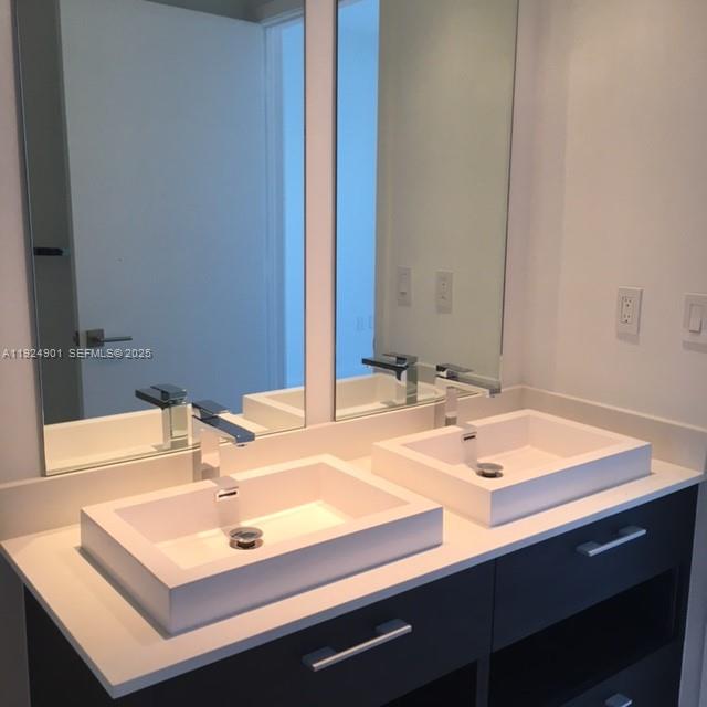 45 Southwest 9th Street, Unit 3201 Miami, FL 33130 - Photo 16 of 19 a bathroom with a sink vanity and a mirror