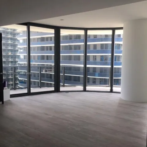 a view of an empty room with windows and city view