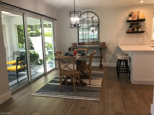 a dining room with furniture a chandelier and wooden floor