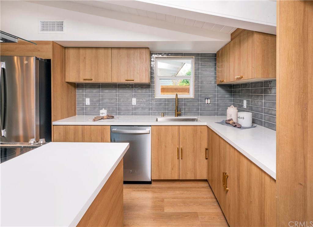 3316 North Studebaker Road Long Beach, CA 90808 - Photo 7 of 29 a kitchen with stainless steel appliances a sink stove and cabinets