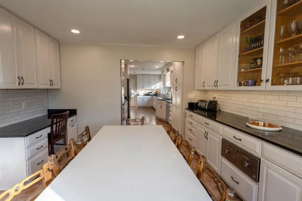 a large kitchen with stainless steel appliances a large counter top a stove and a refrigerator