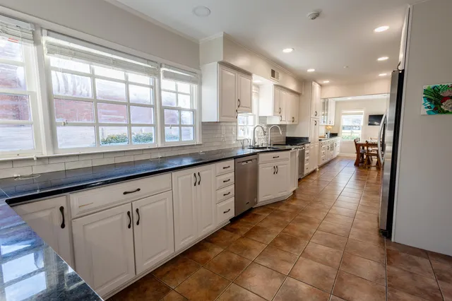a large kitchen with stainless steel appliances lots of counter space and windows