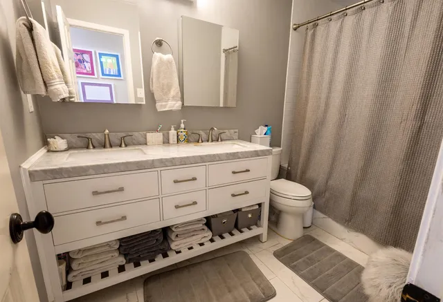 a bathroom with a sink a toilet and a mirror