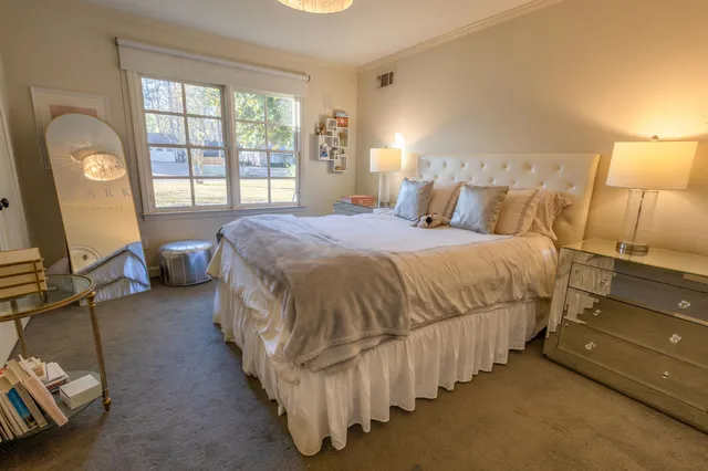 a bedroom with a bed chair and window
