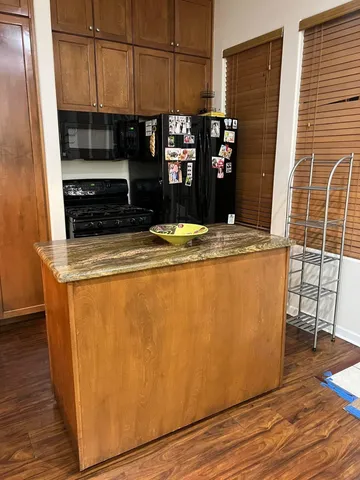 a view of a refrigerator a stove a microwave and cabinets