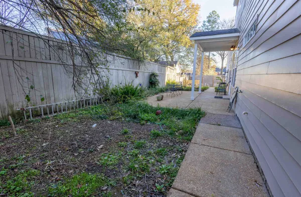 a view of a pathway of a house with a small backyard