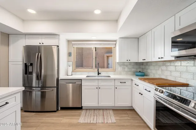 a view of kitchen with cabinets table and chairs