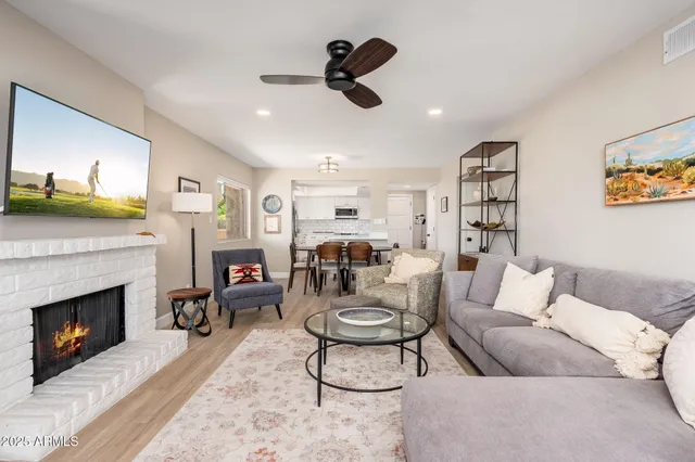a living room with furniture a fireplace and a flat screen tv