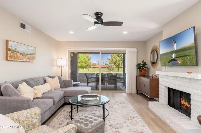 a living room with furniture a fireplace and a flat screen tv