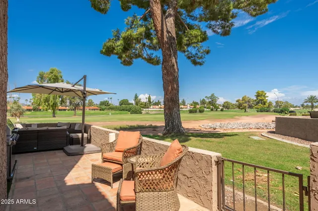 a view of a roof deck with table and chairs barbeque with wooden floor and a yard