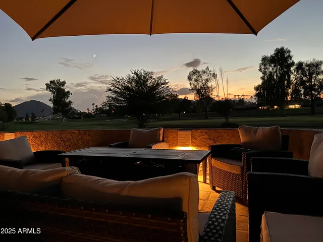 a roof deck with table and chairs and potted plants