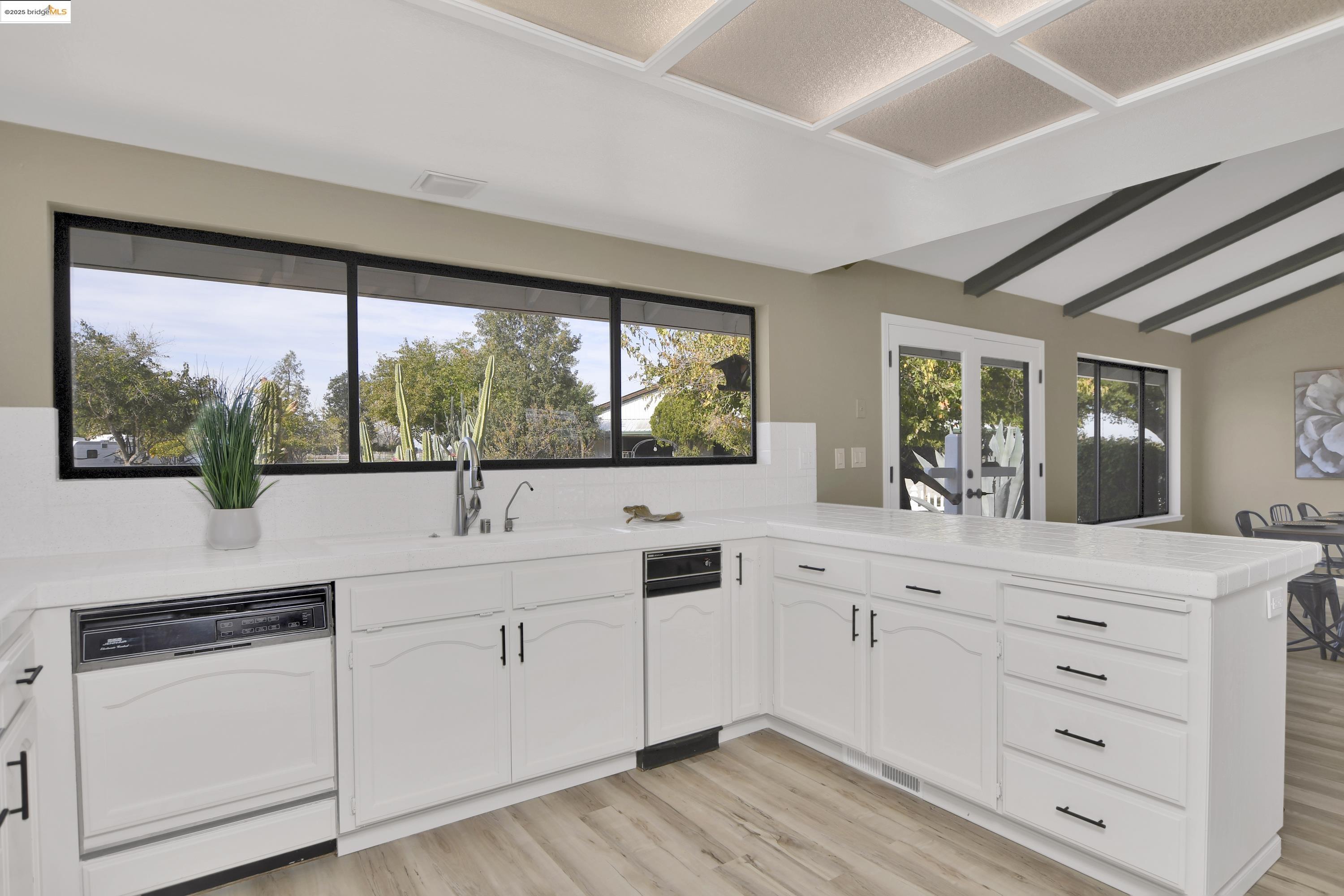 23701 Marsh Creek Road Brentwood, CA 94513 - Photo 11 of 52 a kitchen with white cabinets and a large window
