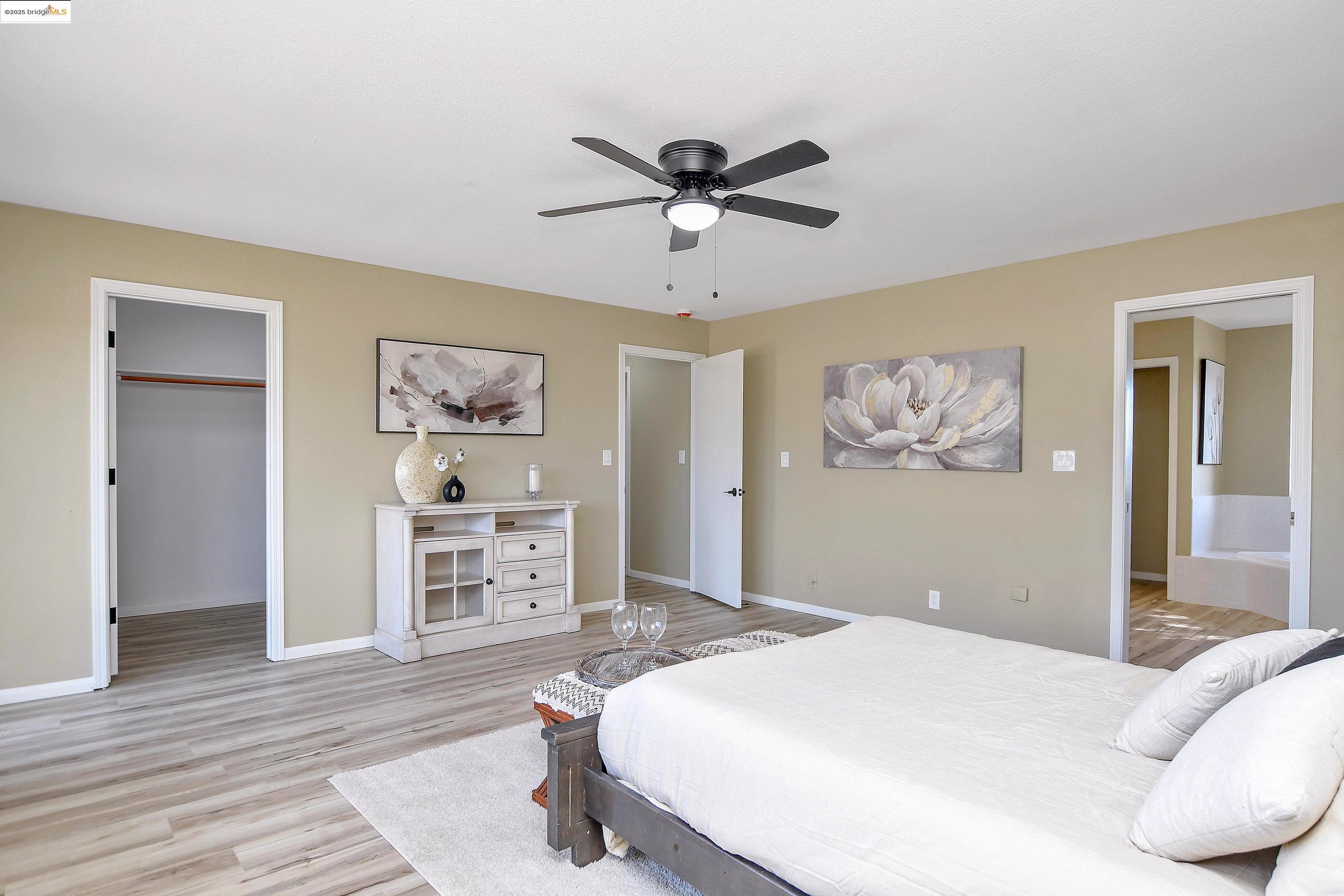 23701 Marsh Creek Road Brentwood, CA 94513 - Photo 17 of 52 a bedroom with a large bed and a chandelier