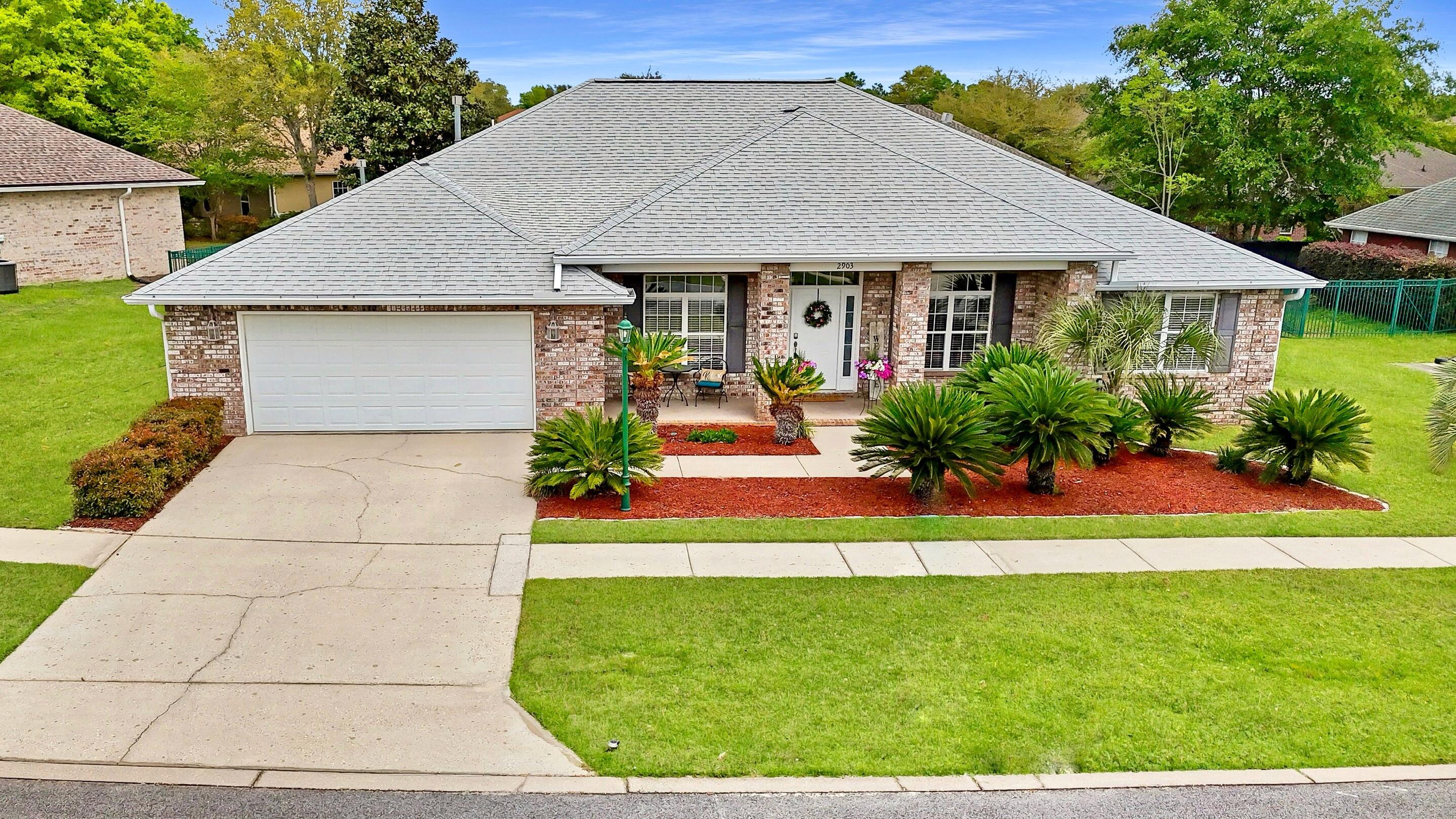2903 Chancery Lane Crestview, FL 32539 - Photo 1 of 43 a front view of a house with a garden