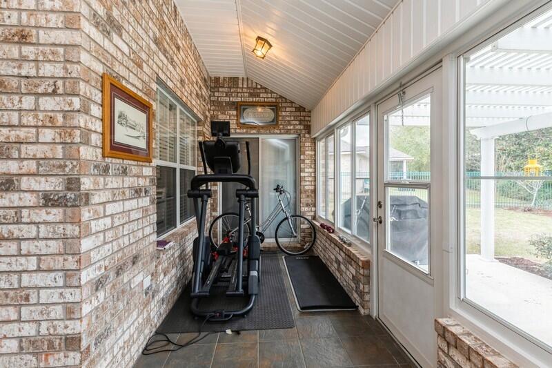 2903 Chancery Lane Crestview, FL 32539 - Photo 19 of 43 a hallway with a couch and a large window with wooden floor