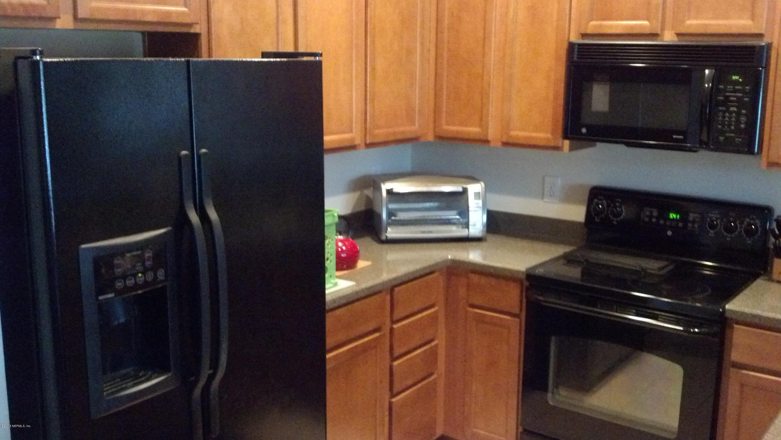 12972 Spring Rain Road Jacksonville, FL 32258 - Photo 3 of 19 a kitchen with a refrigerator stove and microwave