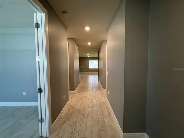a view of a hallway with wooden floor