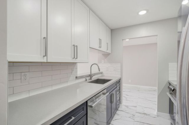 a kitchen with stainless steel appliances a refrigerator and a sink
