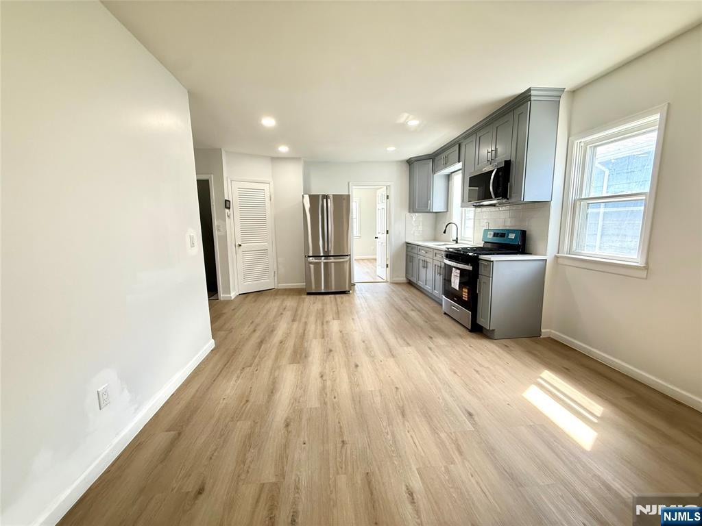 51 Dewitt Street Garfield, NJ 07026 - Photo 3 of 16 a view of a kitchen with wooden floor and electronic appliances