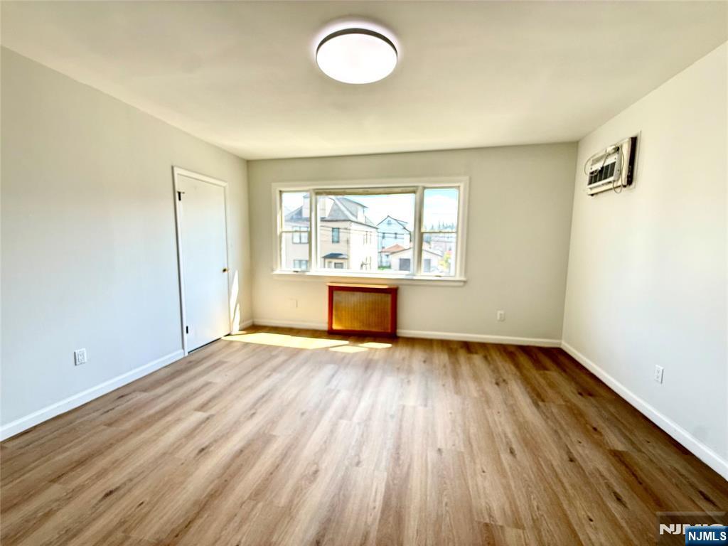 51 Dewitt Street Garfield, NJ 07026 - Photo 7 of 16 an empty room with wooden floor and windows