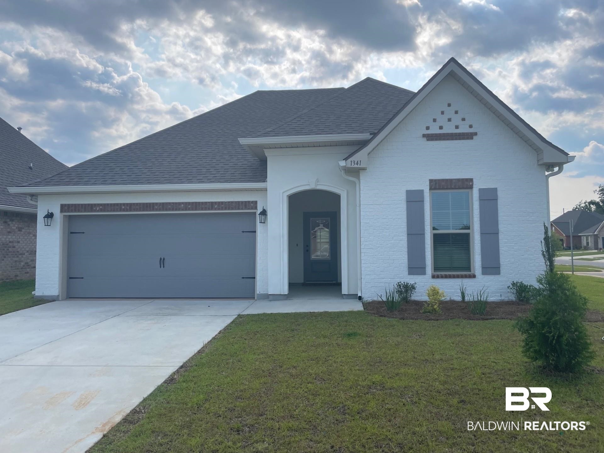 1341 Aldon Street Foley, AL 36535 - Photo 1 of 3 View of front of house featuring a front lawn, a garage, driveway, and a shingled roof