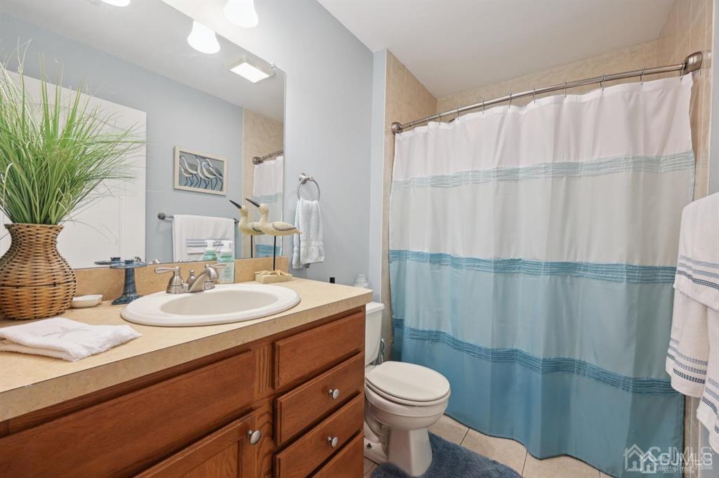 20 Strachan Street Cliffwood, NJ 07721 - Photo 17 of 21 a bathroom with a sink a toilet a mirror and shower curtain
