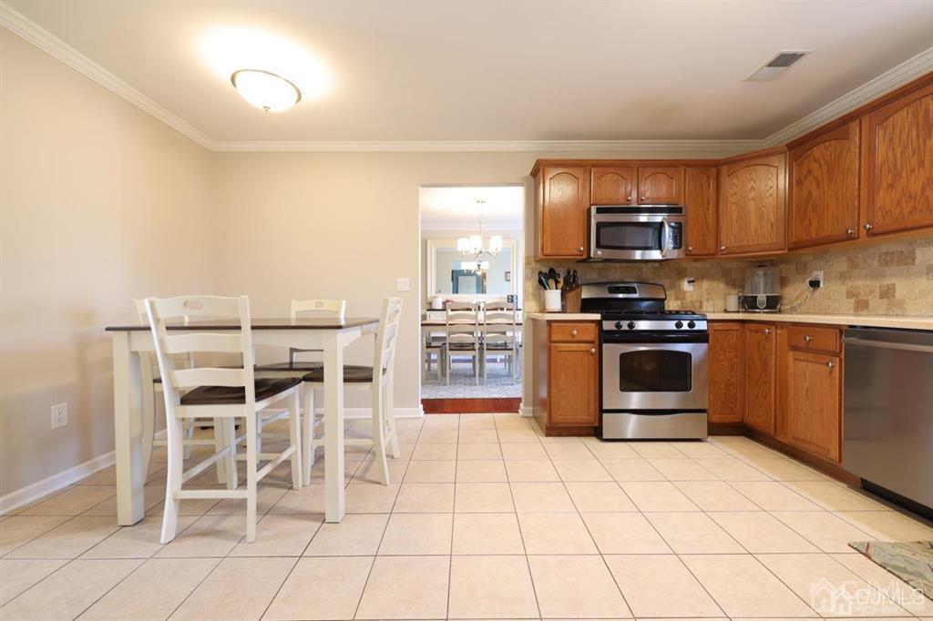 20 Strachan Street Cliffwood, NJ 07721 - Photo 7 of 21 a kitchen with stainless steel appliances a stove a sink cabinets and a dining table