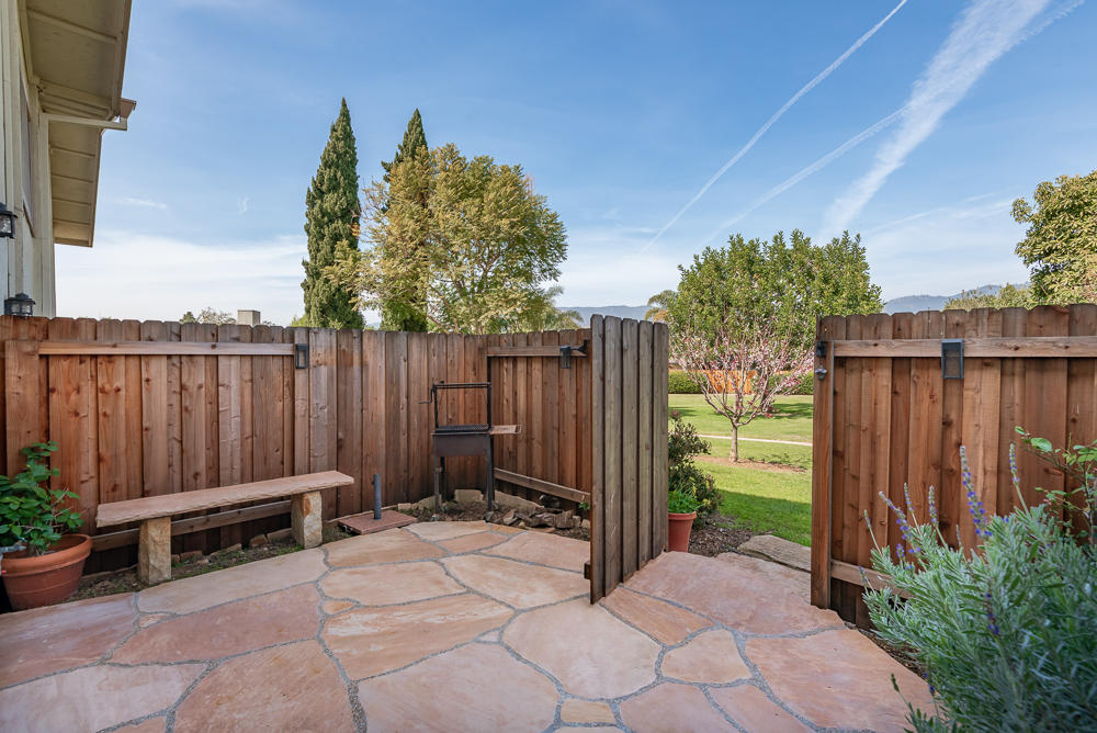 a view of backyard with wooden fence and trees