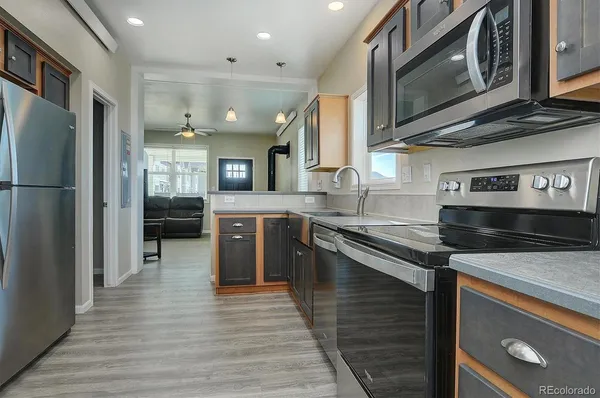 a kitchen with stainless steel appliances granite countertop a refrigerator a stove microwave and cabinets