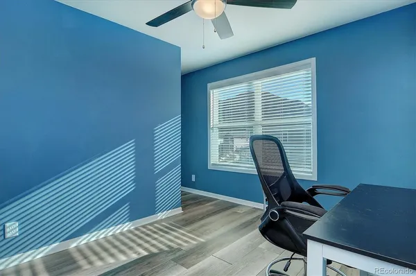 a view of a workspace with furniture and a window
