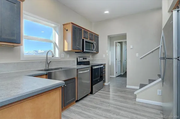 a kitchen with stainless steel appliances granite countertop a sink stove and refrigerator