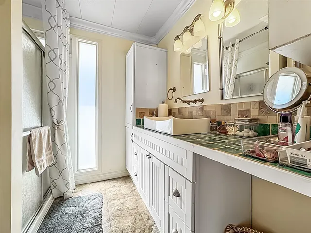 a bathroom with double vanity and a mirror