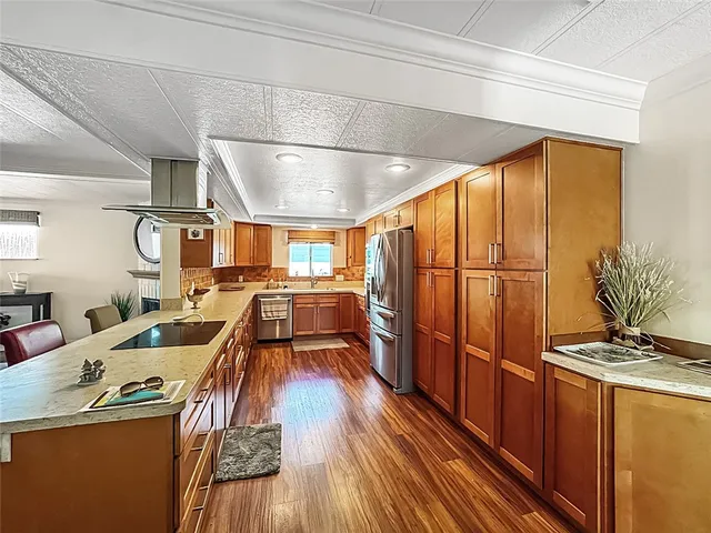 a kitchen with stainless steel appliances granite countertop a sink and wooden cabinets