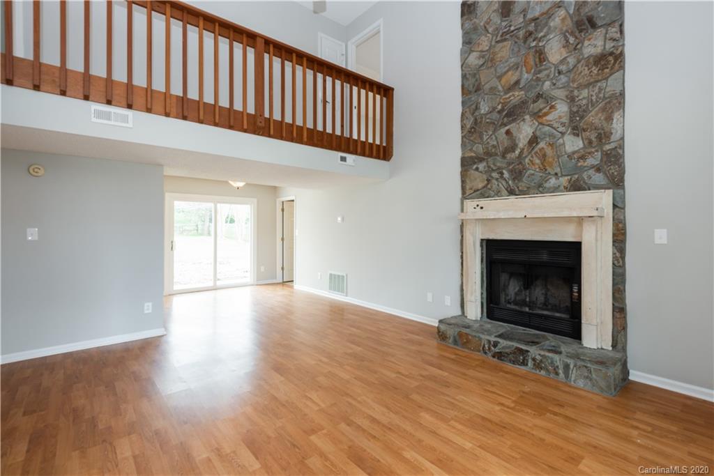 10602 Fairway Ridge Road Charlotte, NC 28277 - Photo 4 of 32 a view of an empty room with wooden floor fireplace and a window
