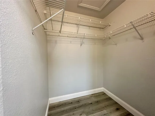 a view of a hallway with wooden floor and a living room